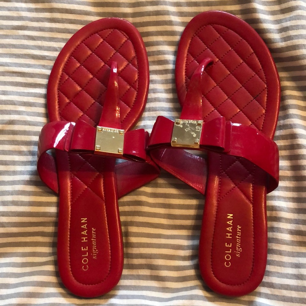 Bright red patent leather and gold hardware Cole Haan bow jelly sandals.